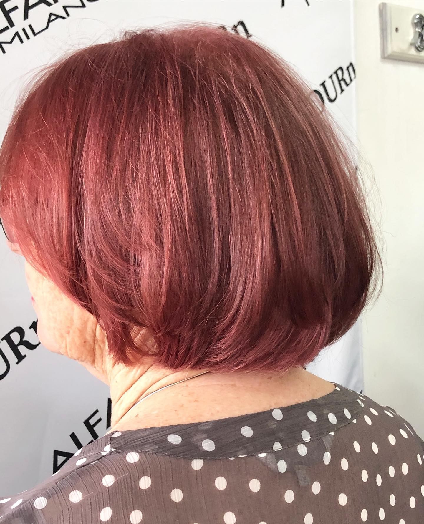 A woman with red hair is wearing a polka dot shirt.