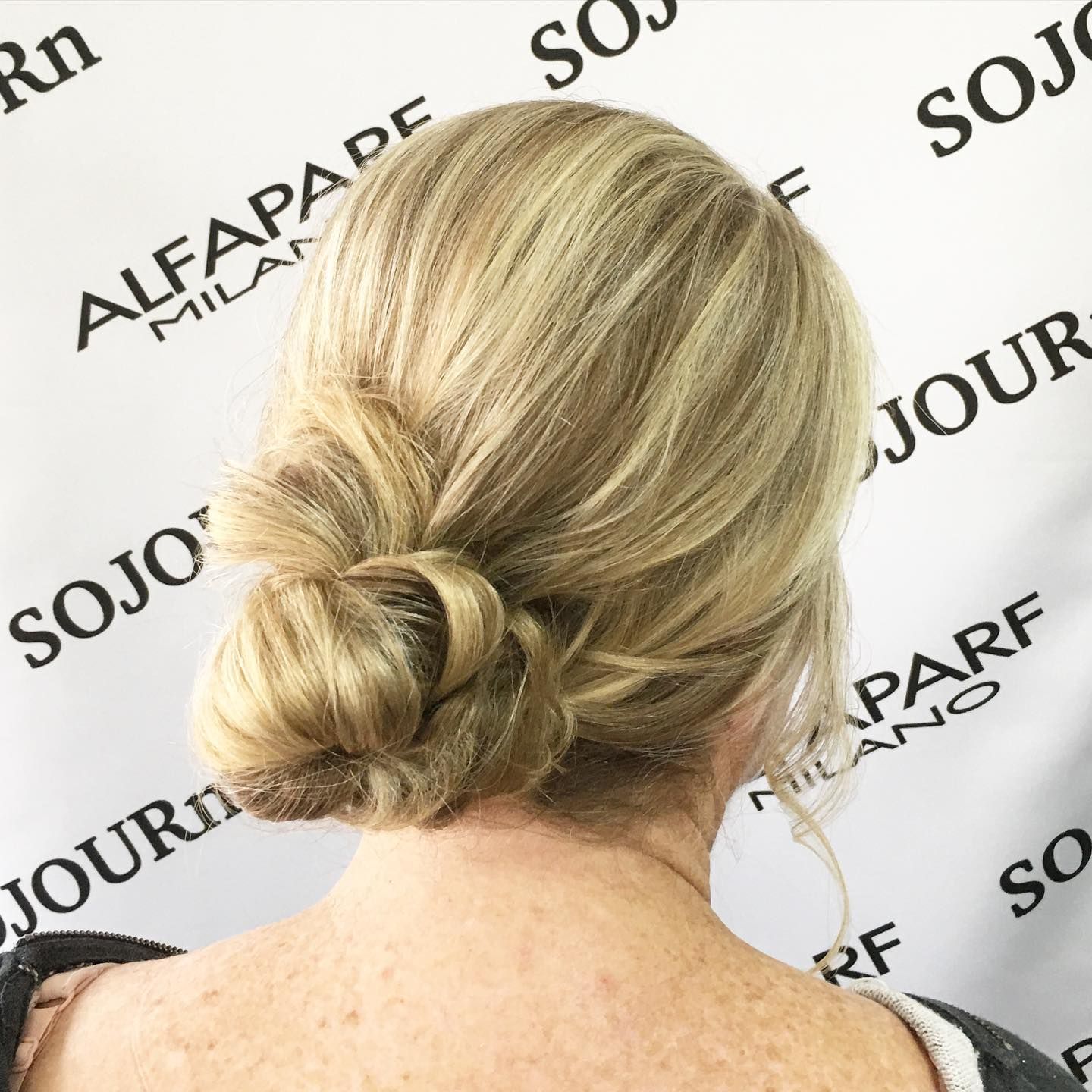 A woman 's back is shown with her hair in a bun