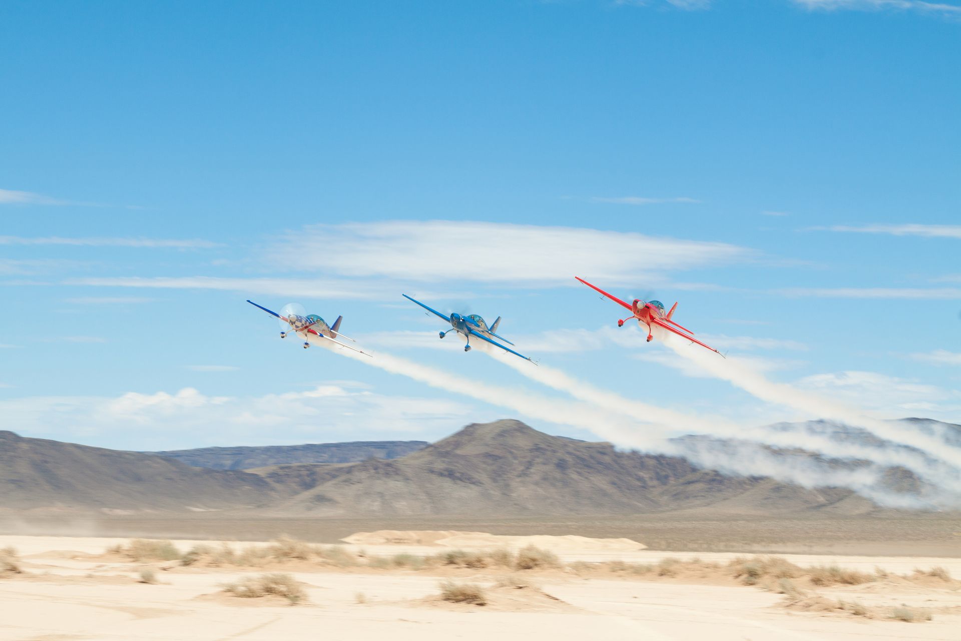 Three stunt planes from Sky Combat Ace taking off midflight.
