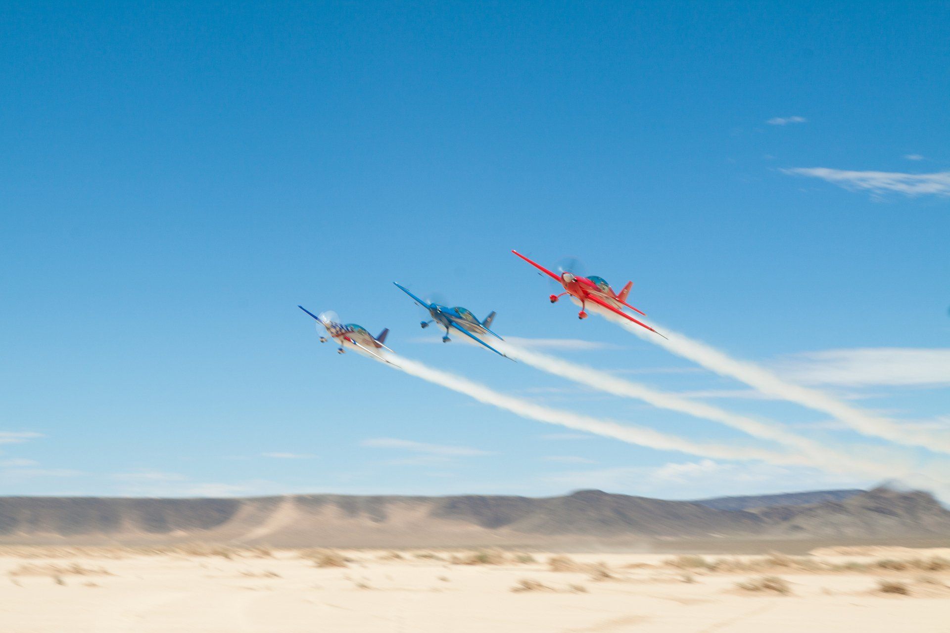 a group of 3 stunt airplanes flying in the sky