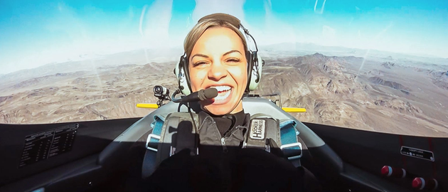 A woman is sitting in the cockpit of an airplane.