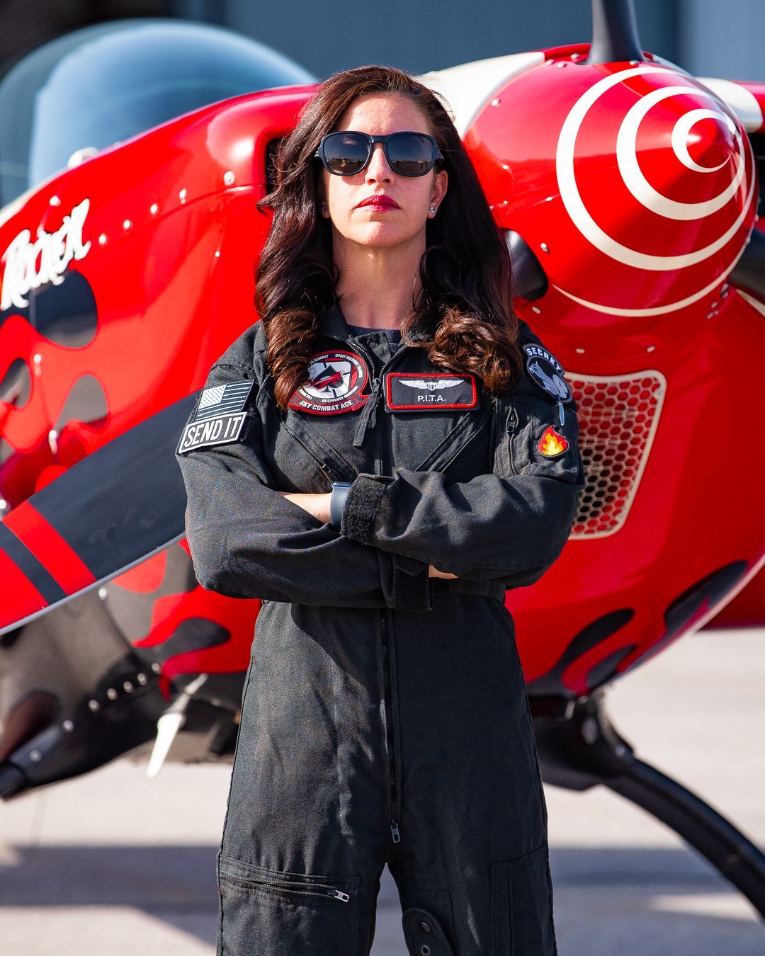 A woman is standing in front of a red jet