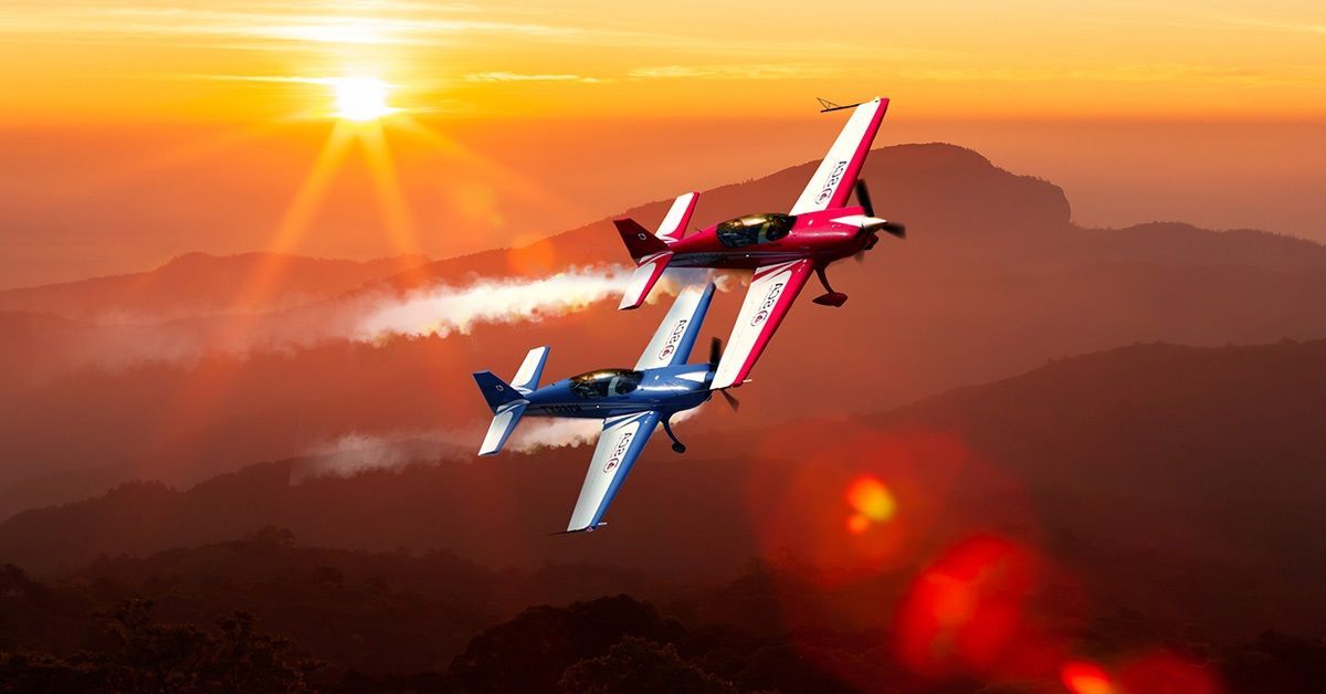 Two Sky Combat Ace planes (blue and red) fly in the air over San Diego.
