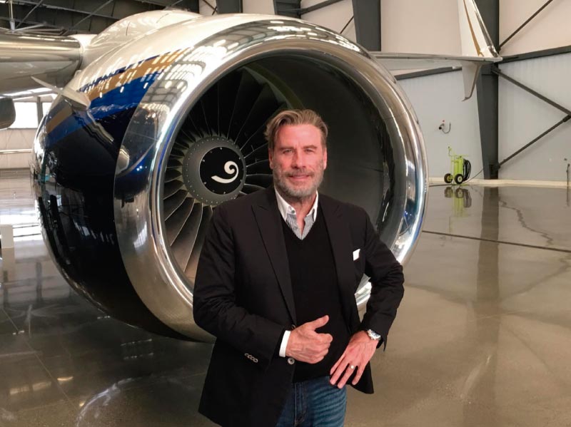 celebrity john travolta with plane behind him