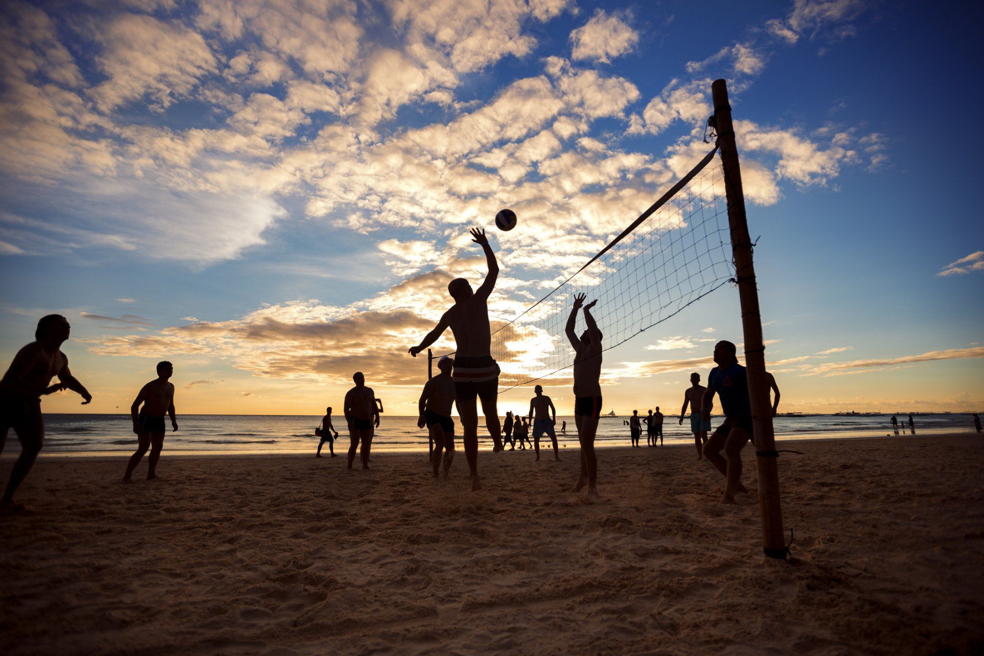 a group of people playing volleyball on a beach in san diego