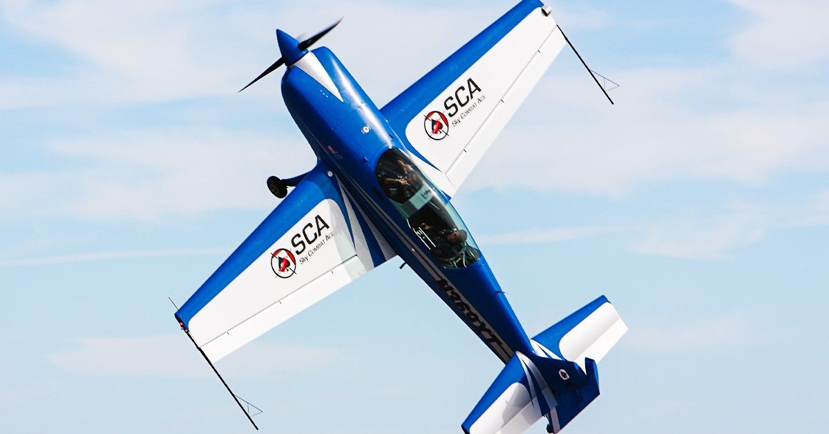 Blue and white Sky Combat Ace plane performing maneuver 
