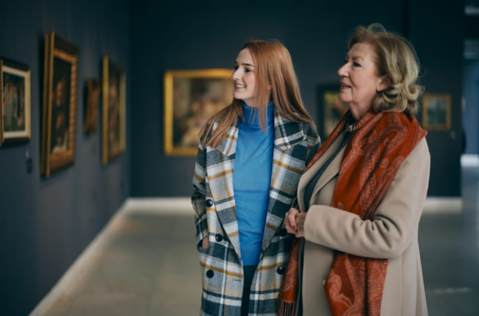 two women are looking at the paintings in the art gallery of a museum