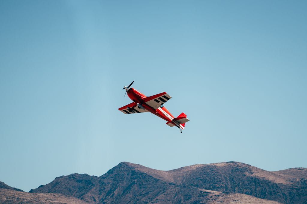 A red Sky Combat Ace plan doing a stunt while flying. 