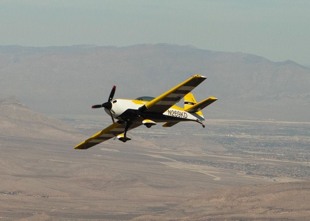 A yellow Sky Combat Ace plan flying in the air. 