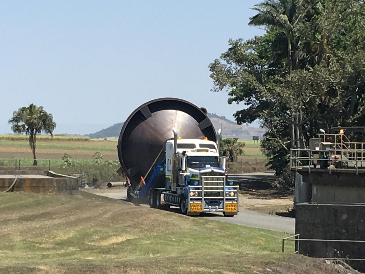 A Truck Is Carrying a Large Object Down a Road — Col Adamson Transport Pilot Services In Farleigh, QLD