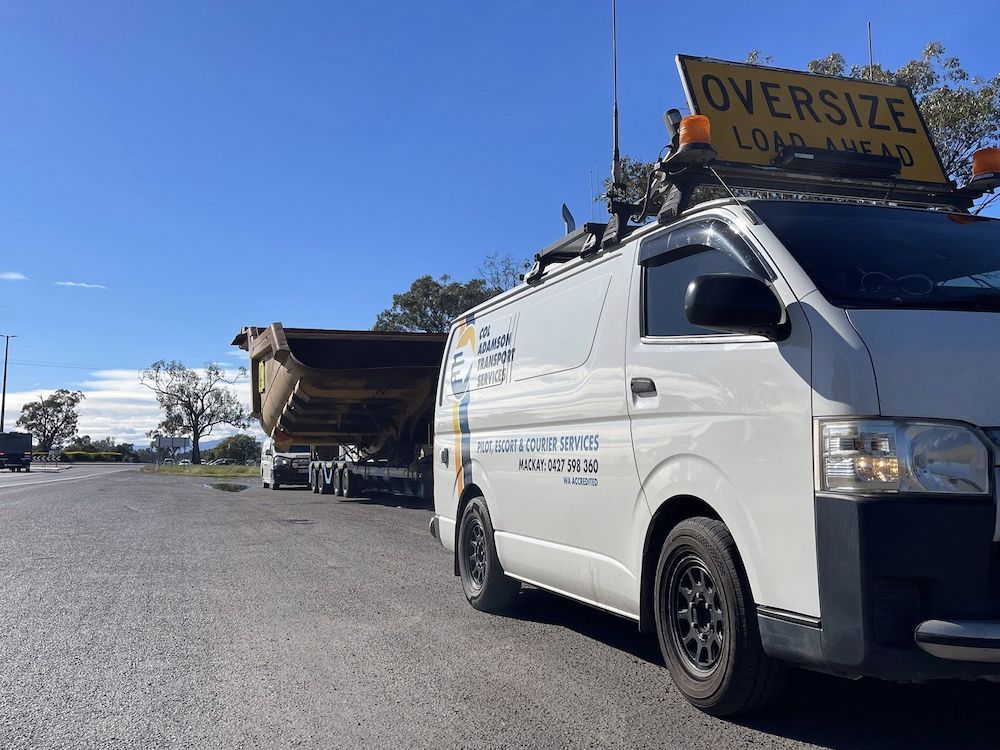 A White Van is Escorting a Big Semi Truck With a Big Object — Col Adamson Transport Services in Farleigh, QLD