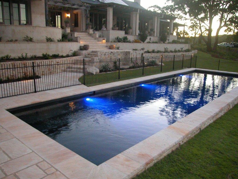 A Swimming Pool Illuminated By Blue Lights Beneath The Water — Byron Bay Luxury Pools in Yamba, NSW