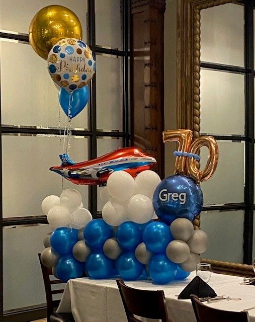 A fun table top display for a pilot turning 70 with helium balloons, an airplane and mylar numbers.