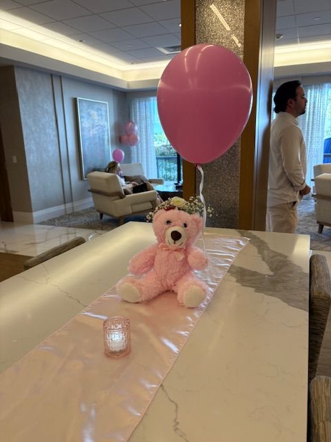 A table setting with pink glass votive candle holder and white flameless, timed votive candles.