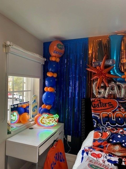 A decorated bedroom with a neon alligator on the desk.