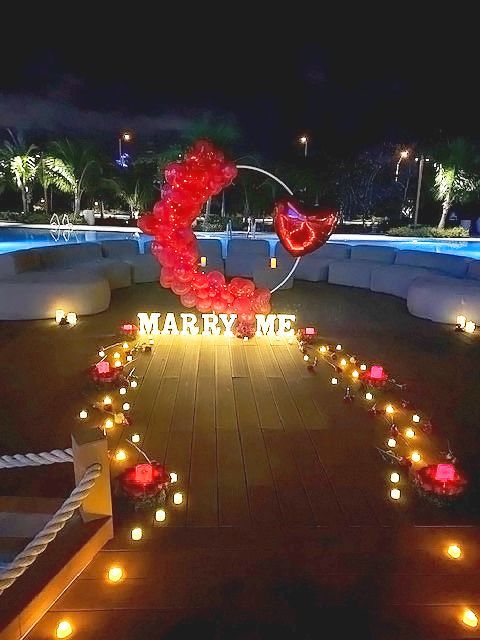 Pool side at the Hard Rock's Guitar pool this New Years Eve proposal was the perfect setting for the nervous groom to be to pop the question. It included a candle lit path way filled with roses, marquee letters that read Marry Me and a red organic balloon Garland. Hard Rock Hotel, Hollywood Florida, curated by An Elegant Picnic.