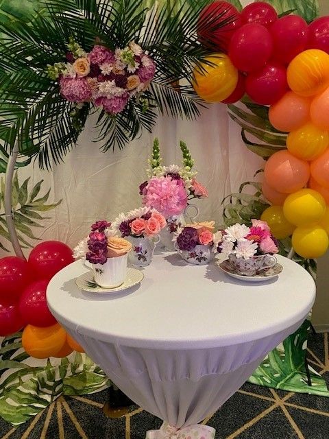 A decorated table with vintage china tea cups filled with fresh flowers. Create for a high tea setting at the Jacaranda Country Club Event.