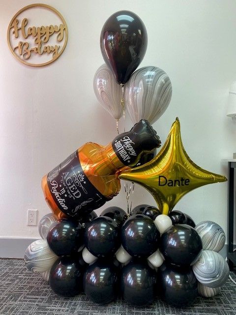 A black, gold and silver birthday marquee with a liquor bottle to celebrate a 21st birthday.