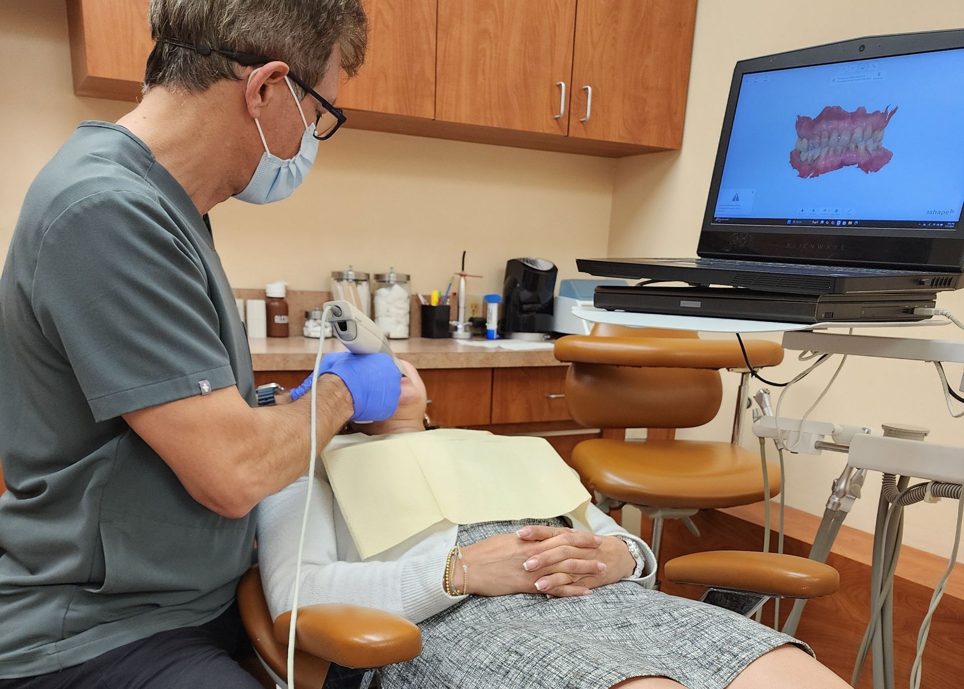 A dentist is examining a woman 's teeth in a dental office.