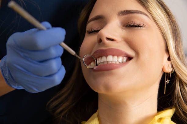 Young woman with a beautiful smile getting her teeth checked by the dentist.