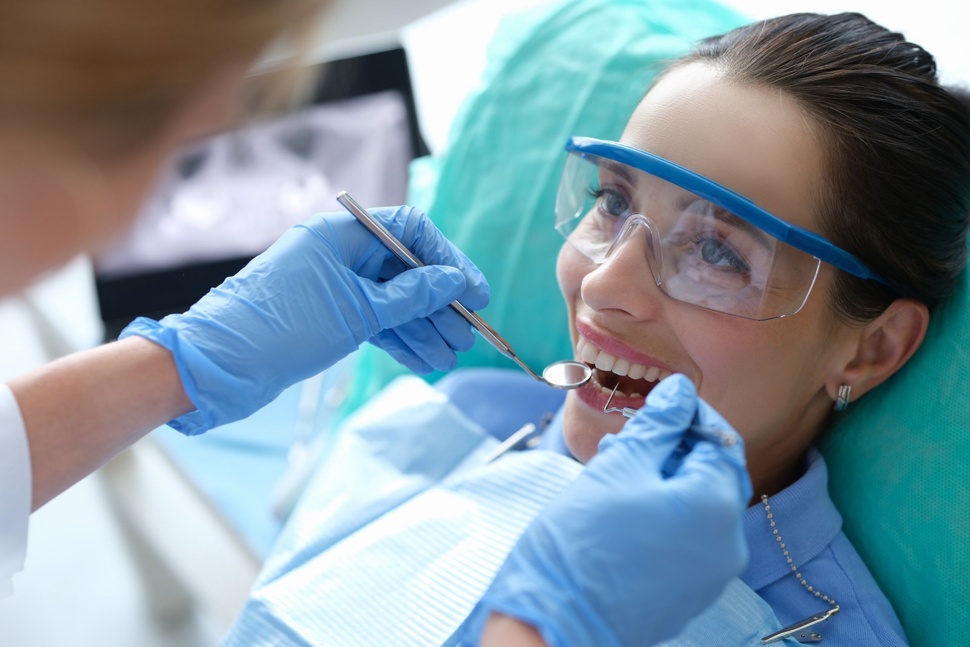 Doctor examining oral cavity of female patient.
