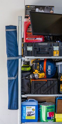 A shelf filled with lots of items in a garage.