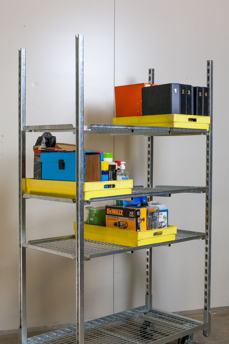 A metal shelf with yellow trays and boxes on it