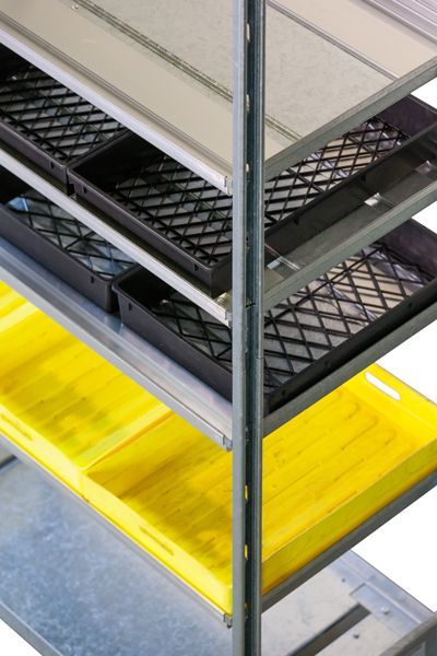 A metal shelf with a yellow tray on the bottom shelf
