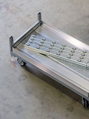 A metal cart with a metal tray on top of it.