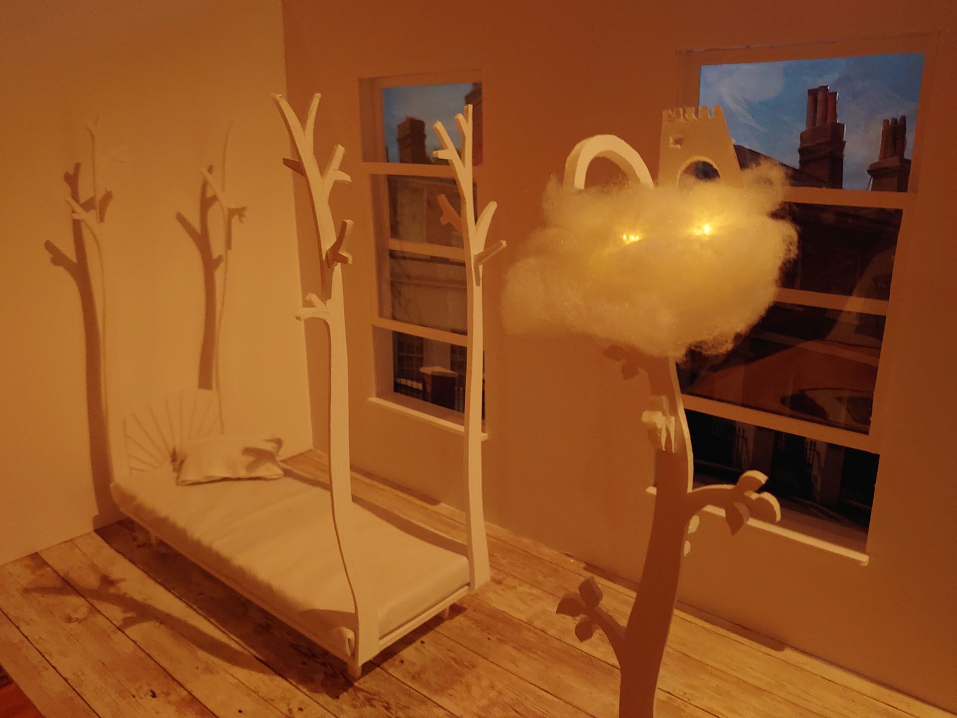 A model of a room with a cloud  on beanstalk lamp and four poster bed with branches as posts. By Matt Sargent.