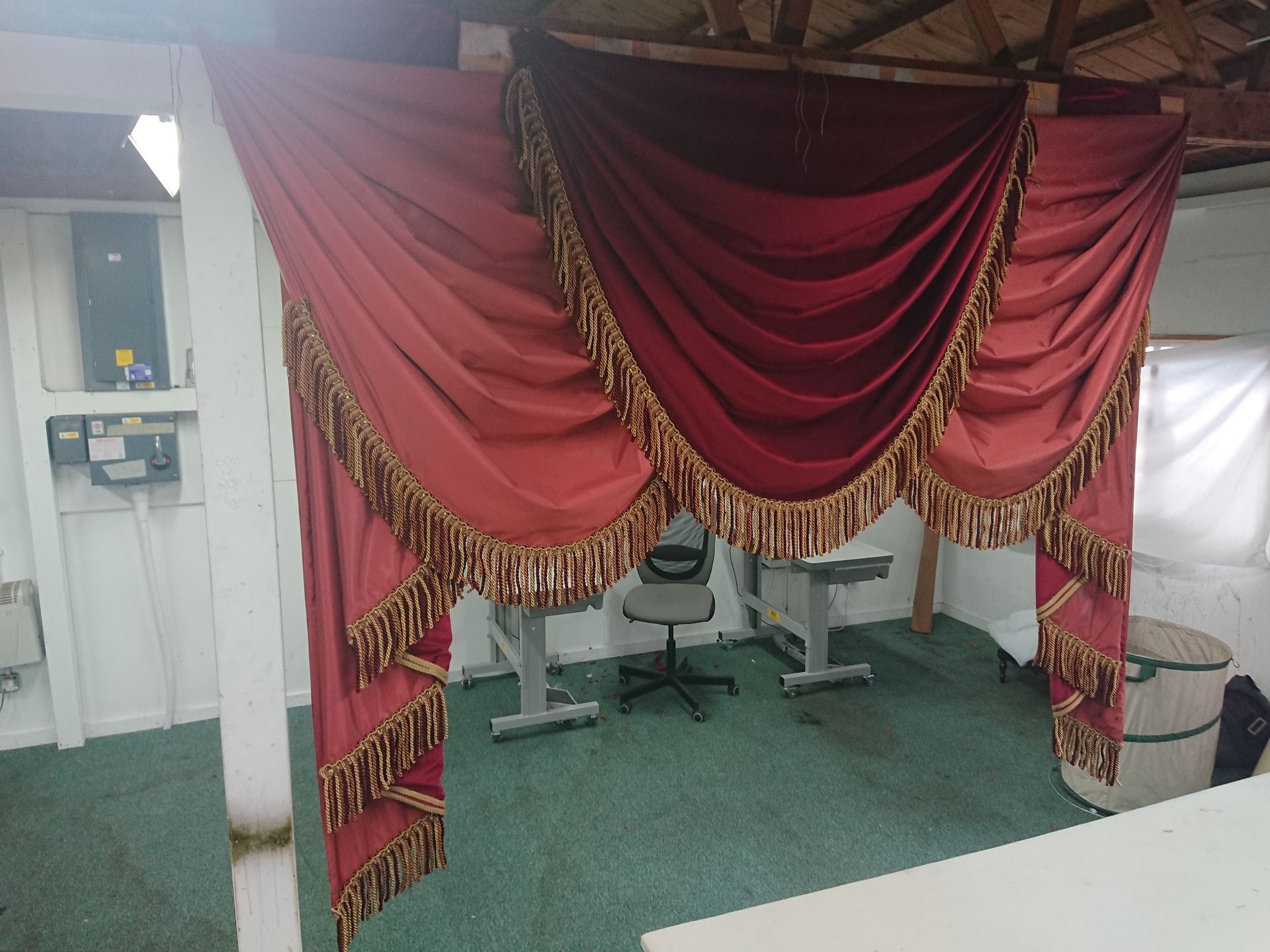 Three overlapping swags in red velvet with accompanying tails made of red velvet.