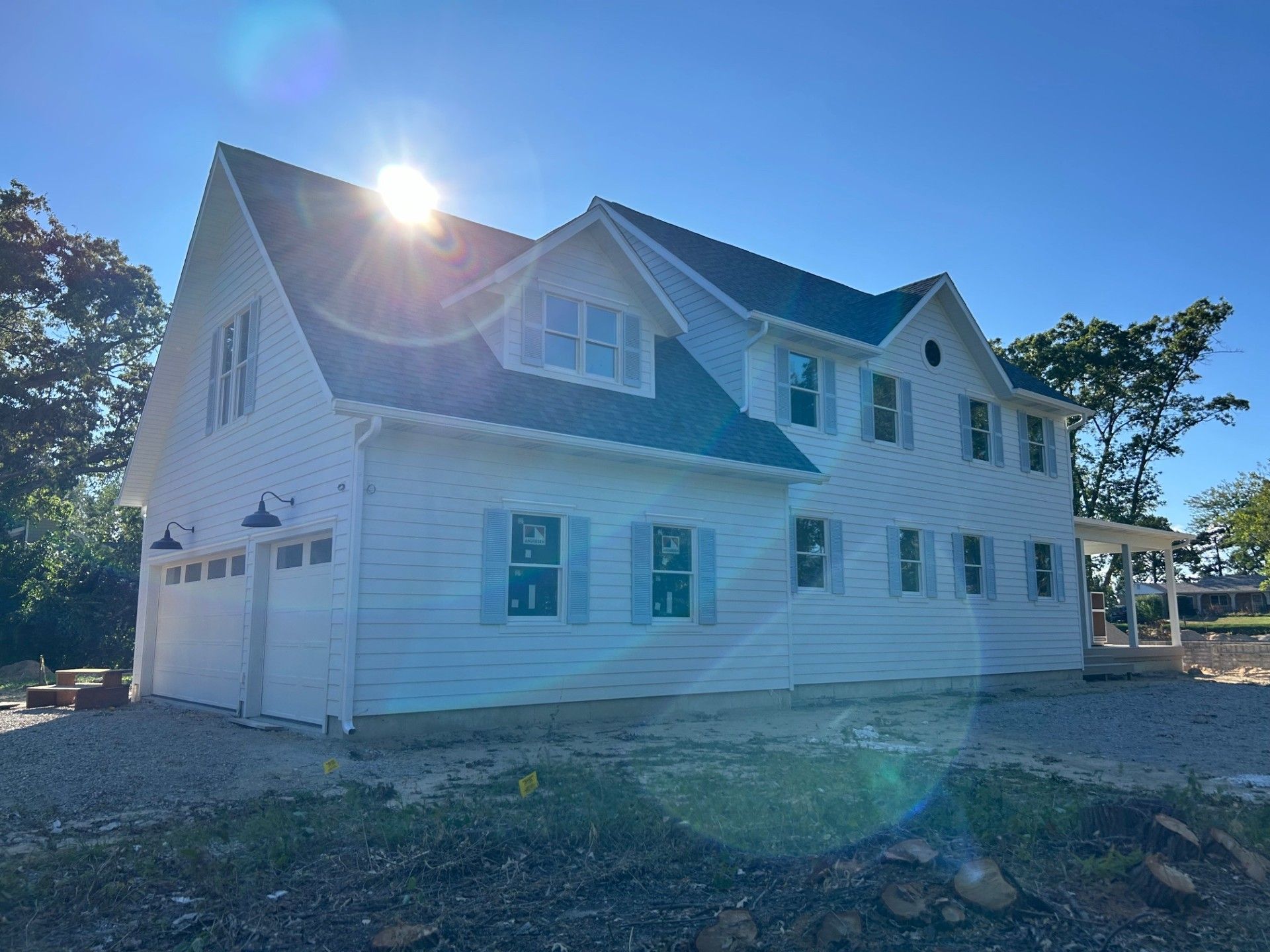 A large white house with a blue roof is being built.