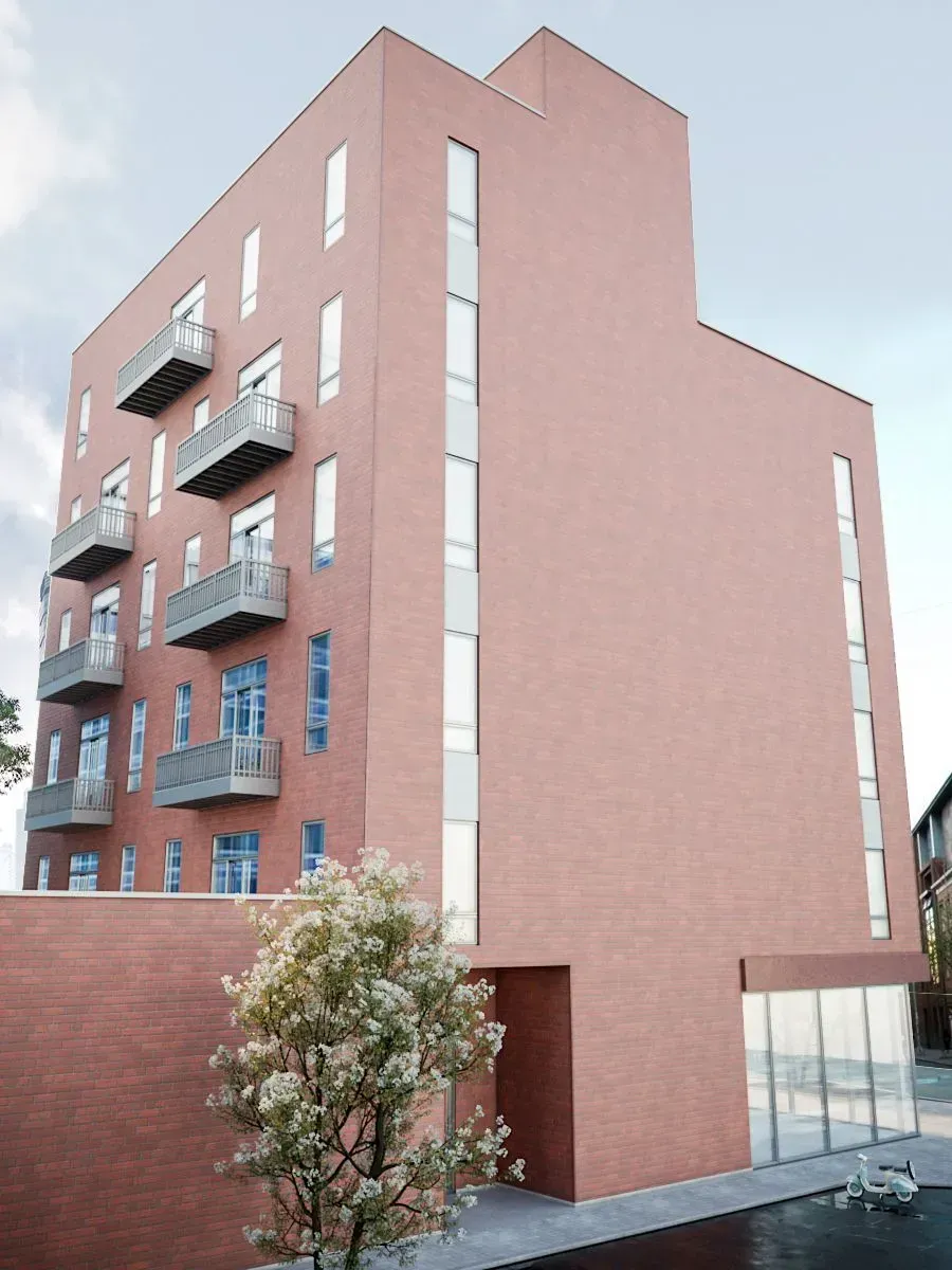 A large brick building with balconies and a tree in front of it