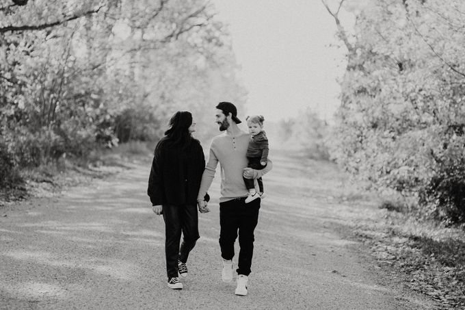 A black and white photo of a family walking down a dirt road.