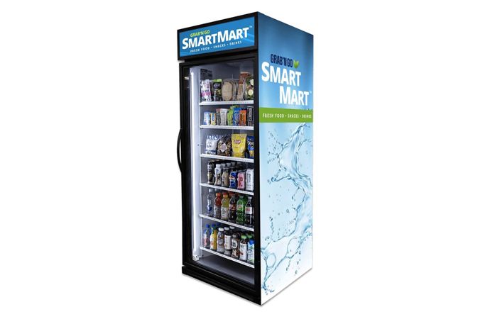SmartMart vending machine with clear front showcasing snacks and drinks. Blue and white branding on top and side.