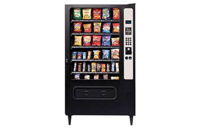 Black snack vending machine with various packaged snacks visible.
