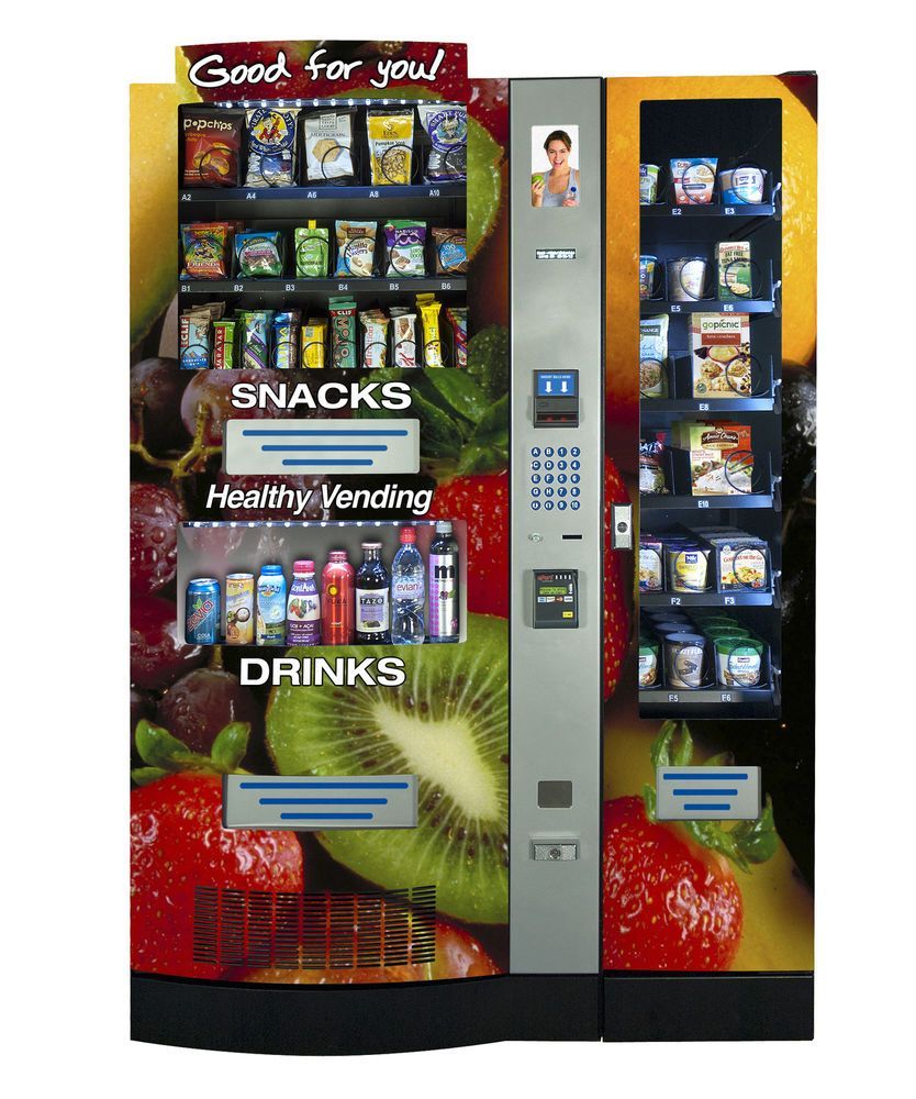 Vending machine offering snacks and drinks, with healthy options, surrounded by fruit.