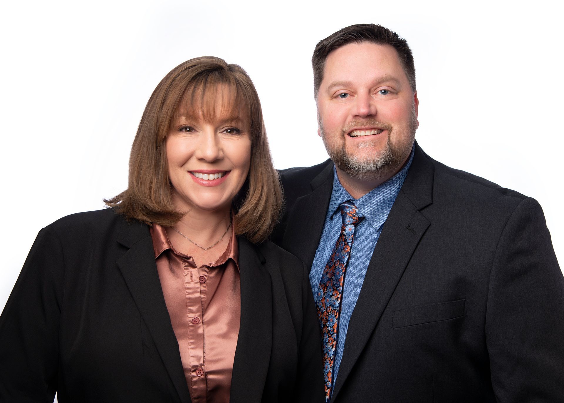 A man in a suit and tie is smiling for the camera.