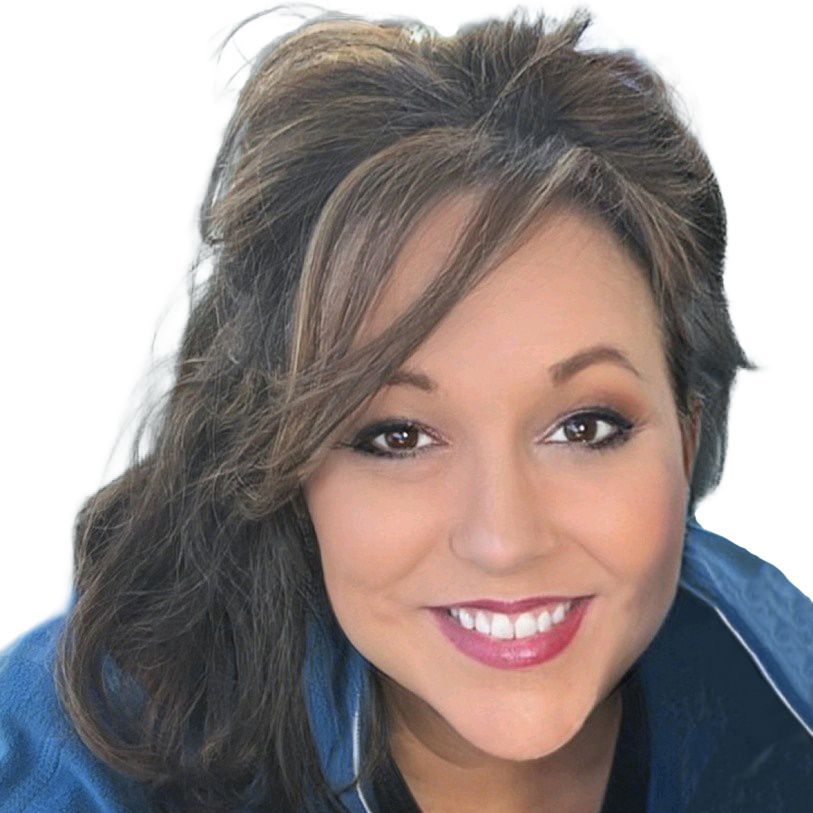 Woman with brown hair smiling, wearing a blue jacket, against a white background.