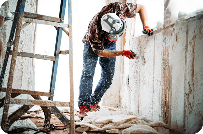 A man is working on the side of a building with a crane.