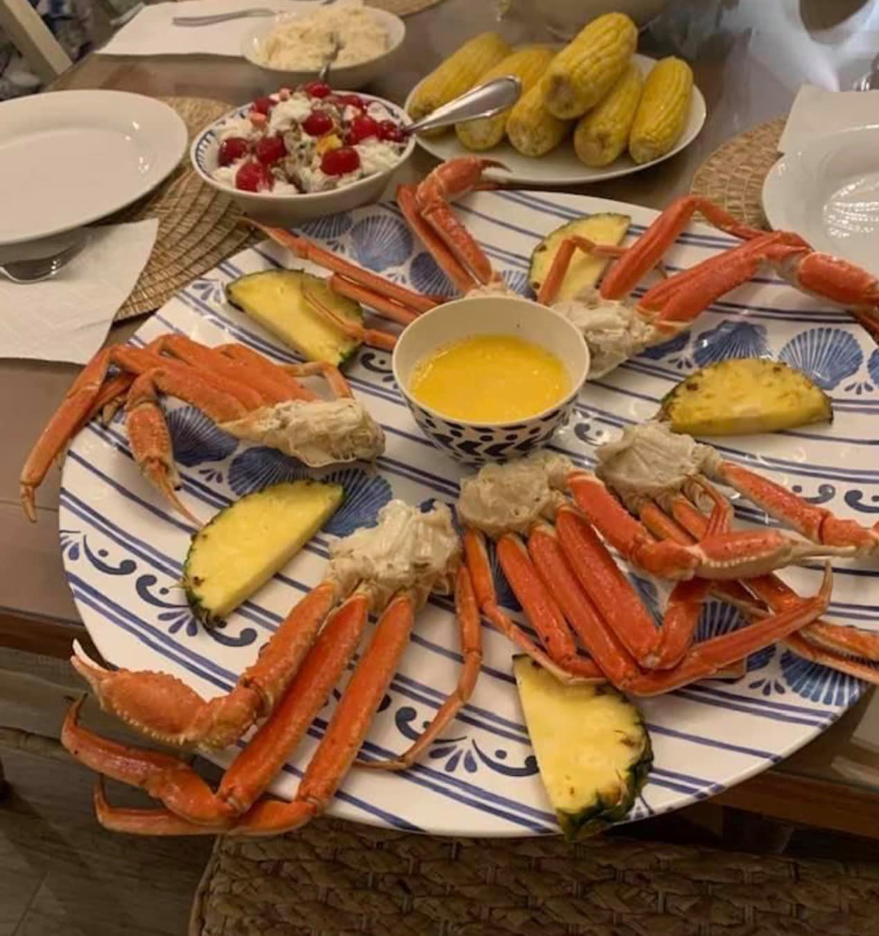 A plate of crab legs and pineapple on a table