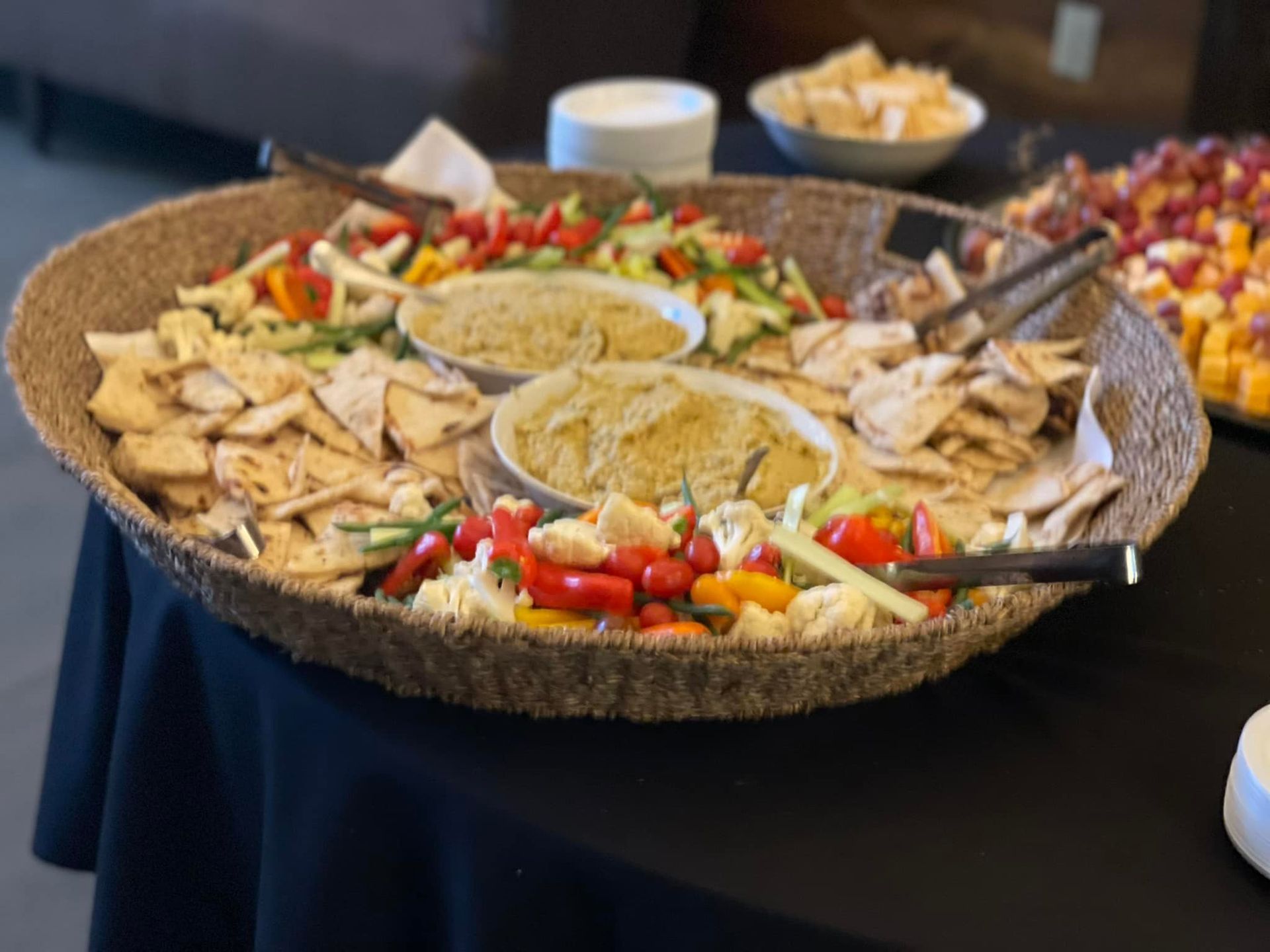 There is a tray of food on the table with a black table cloth.