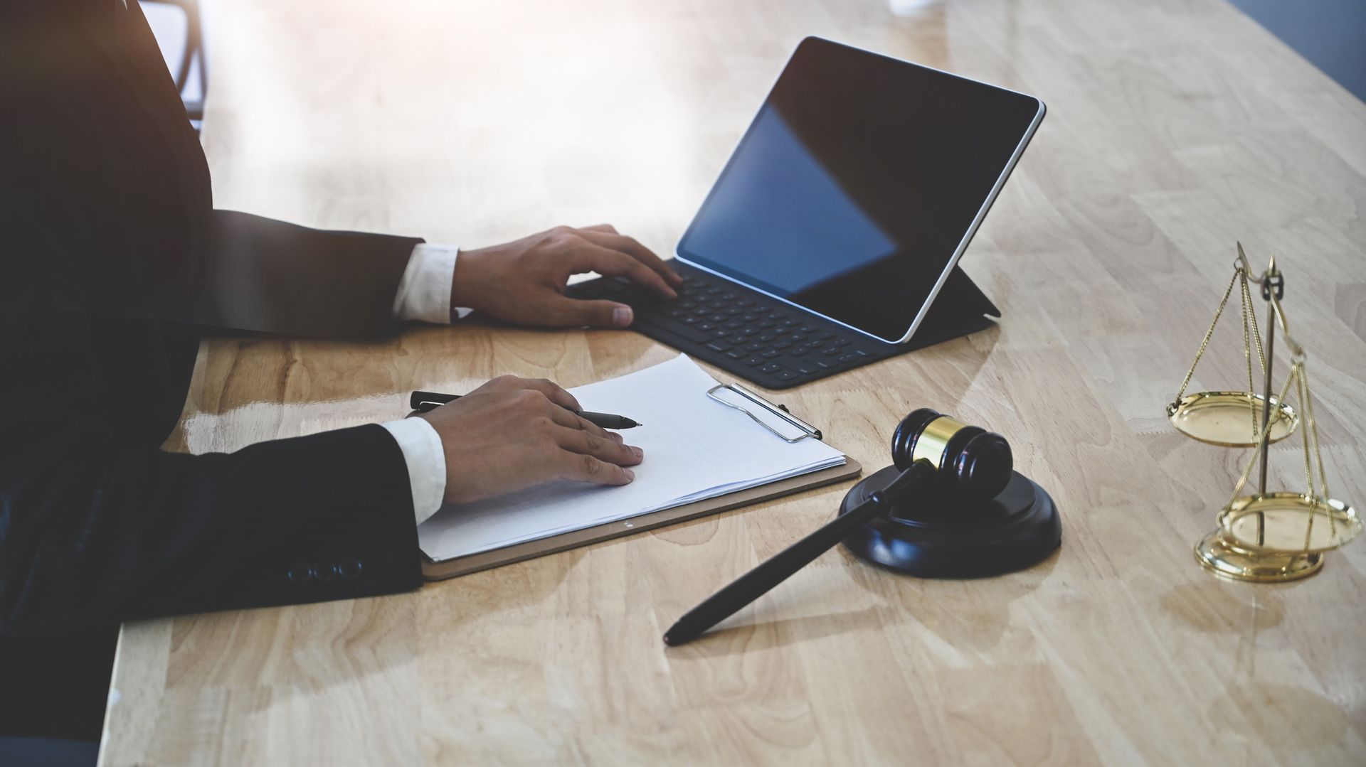 A man is sitting at a table using a laptop computer.