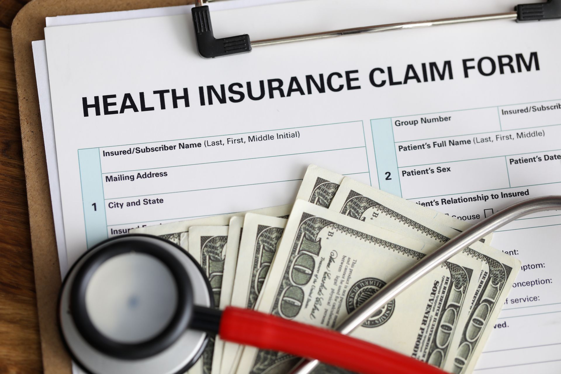 A health insurance claim form with money and a stethoscope on it