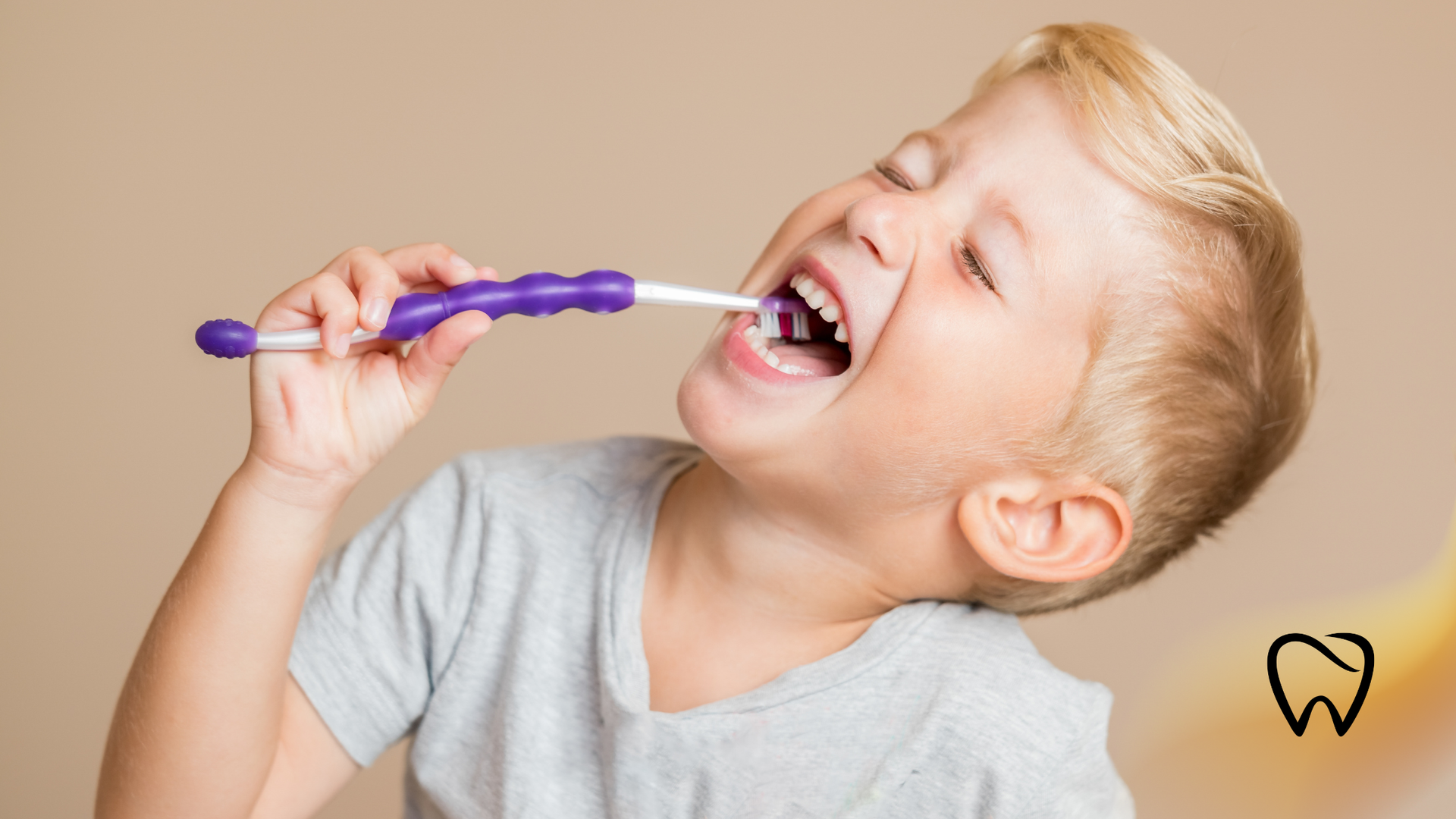 Boy brushing teeth with purple toothbrush.