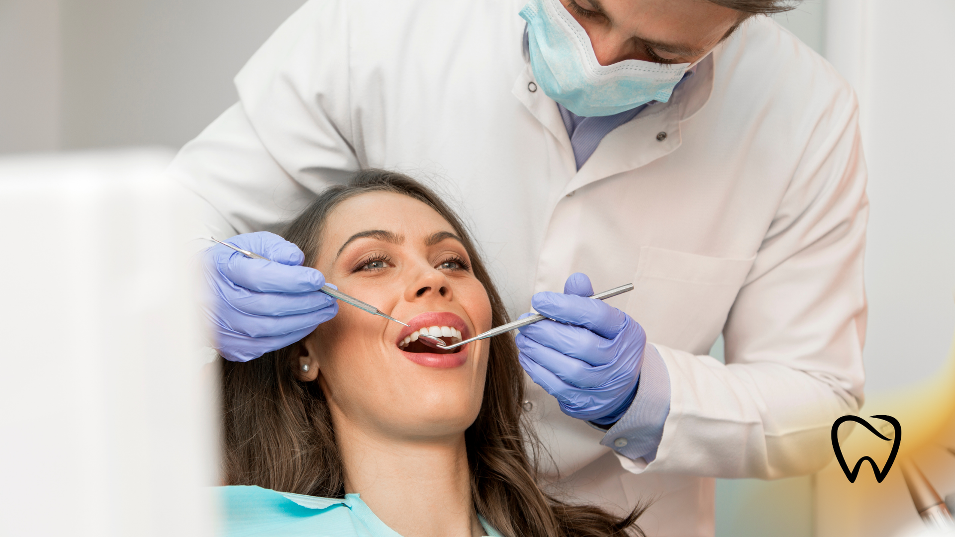 Dentist examining a patient's teeth. The patient is sitting in a chair with mouth open.