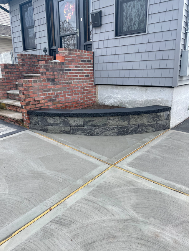 A brick walkway with stairs leading up to the front door of a house.