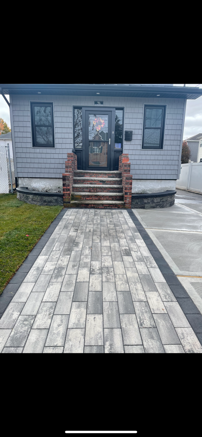A small house with a brick walkway leading to it.