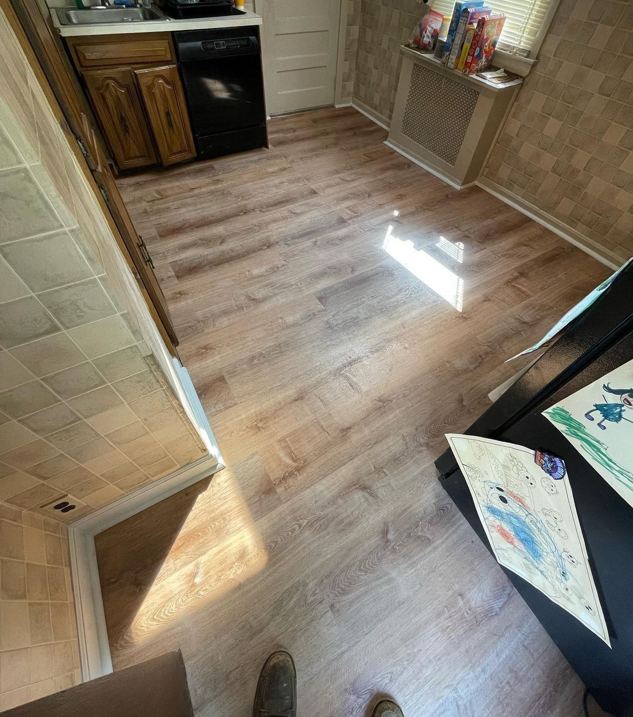 A kitchen with hardwood floors and a black refrigerator.