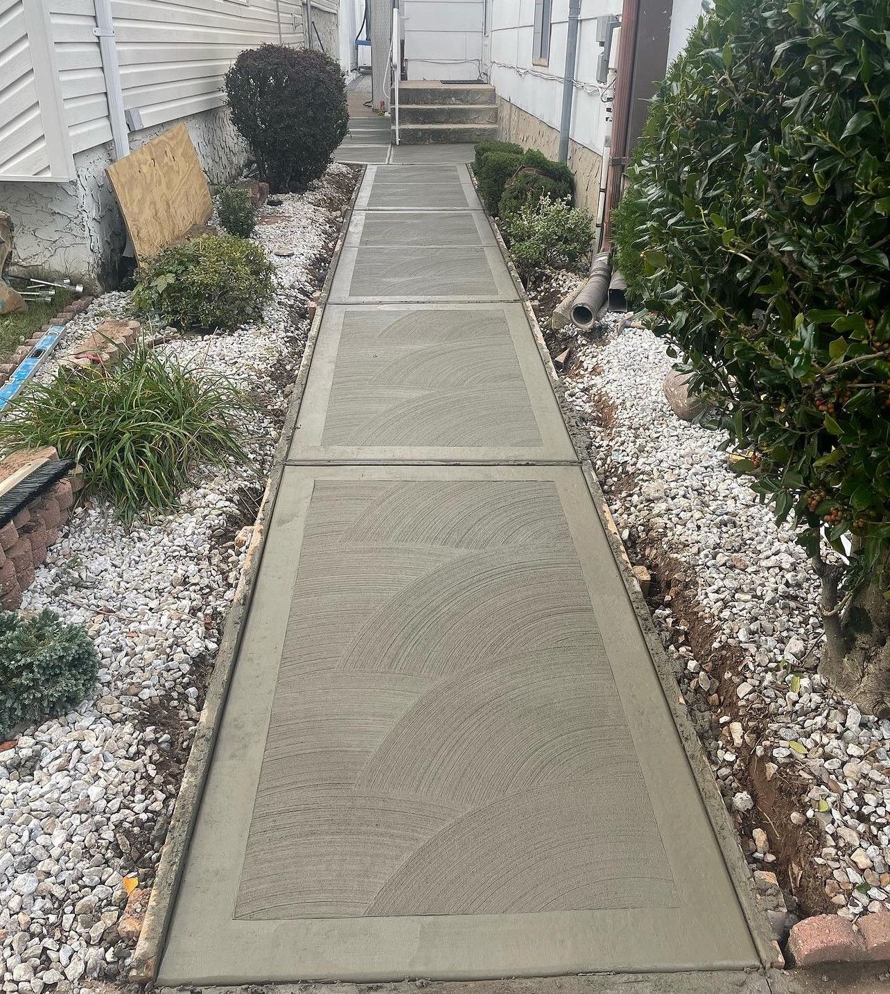 A concrete walkway is being built in front of a house.